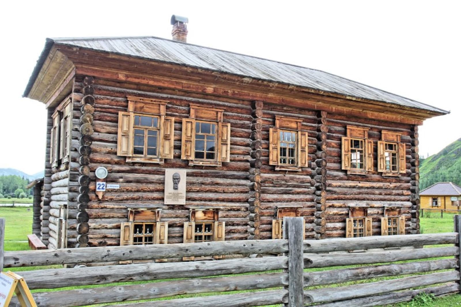 Старинный двухэтажный деревянный дом-сруб с резными ставнями